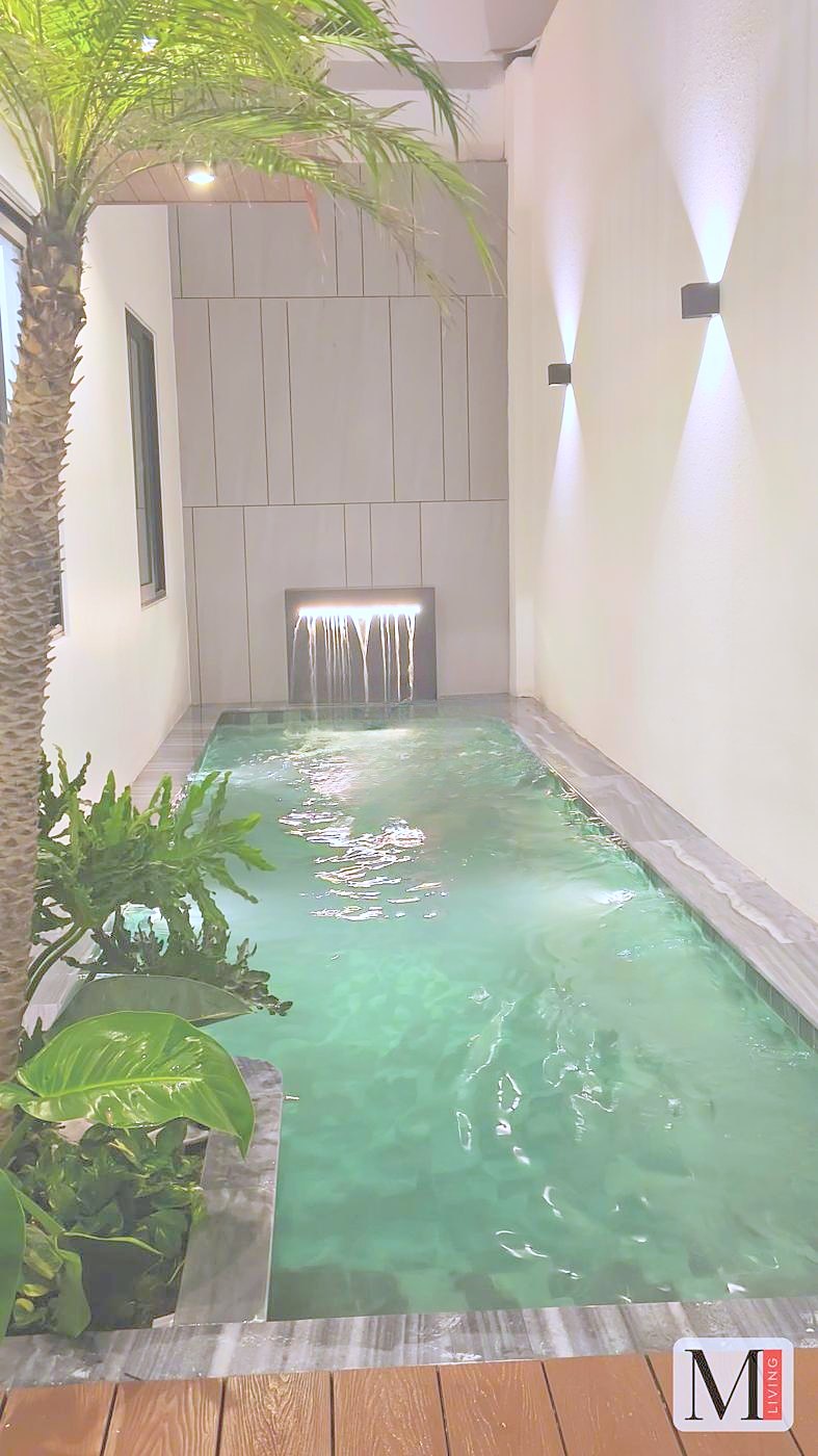 Hồ bơi trong nhà tại M LIVING với thác nước và cây xanh